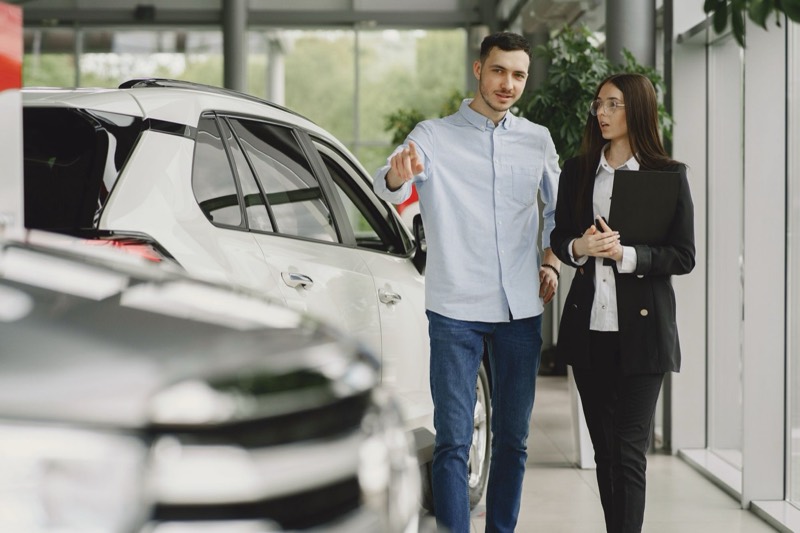 Kundin im Gespräch mit einem Berater in einem Autohaus